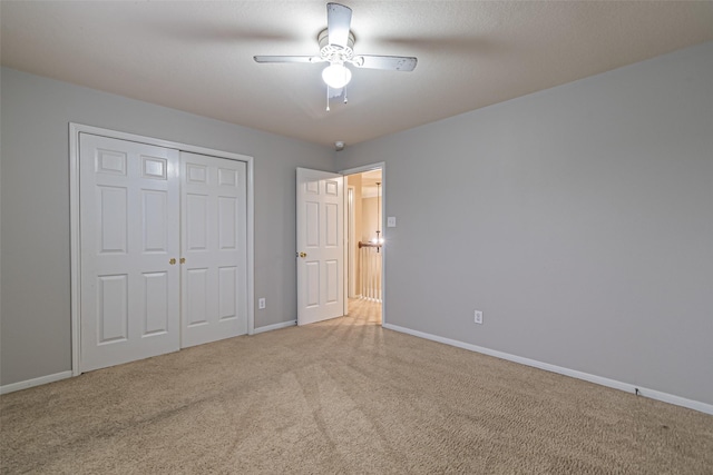 unfurnished bedroom with ceiling fan, a closet, and light carpet