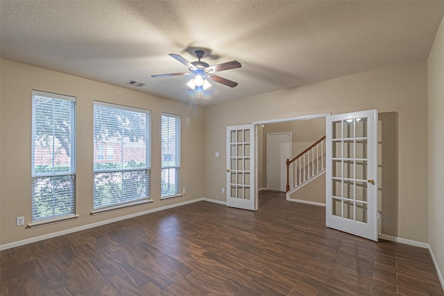 spare room with ceiling fan, dark wood-type flooring, a textured ceiling, and french doors