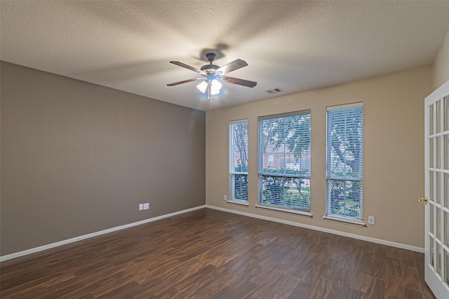 unfurnished room with ceiling fan, dark wood-type flooring, and a textured ceiling