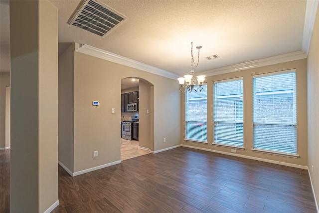 empty room with dark hardwood / wood-style flooring, ornamental molding, and a notable chandelier