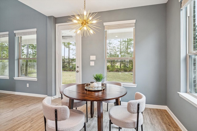 dining room featuring a healthy amount of sunlight, a chandelier, and light hardwood / wood-style floors