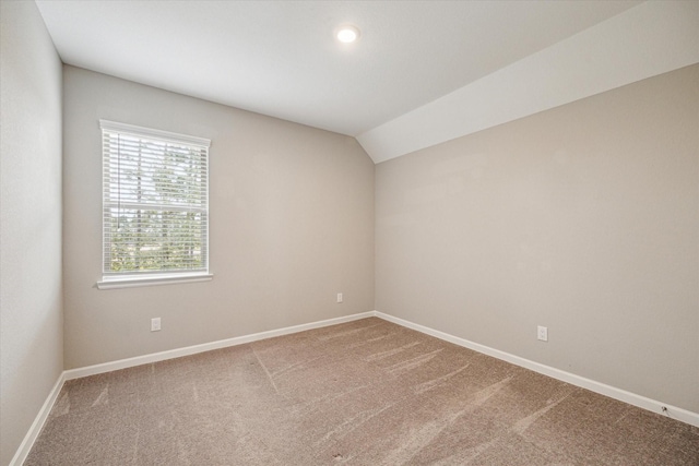 empty room with carpet floors and lofted ceiling