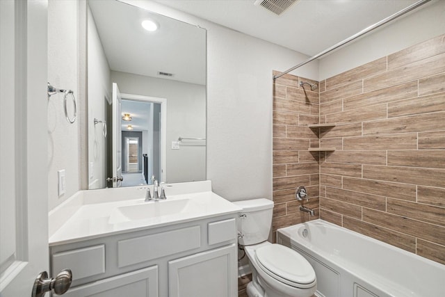 full bathroom with tiled shower / bath combo, vanity, and toilet