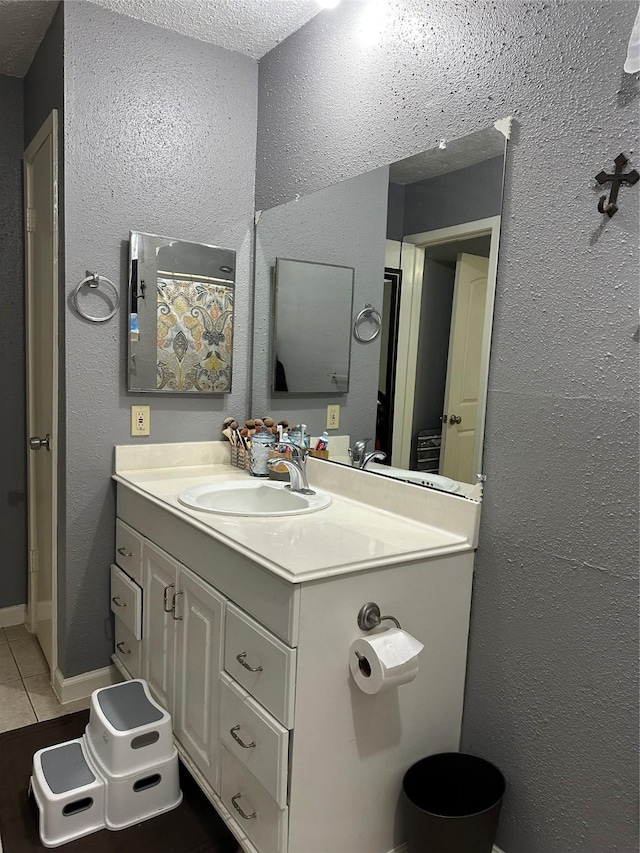 bathroom featuring a textured ceiling, tile patterned floors, and vanity