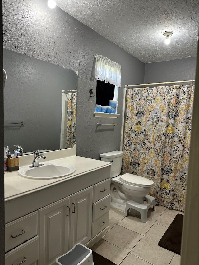 bathroom featuring a textured ceiling, tile patterned floors, vanity, and toilet