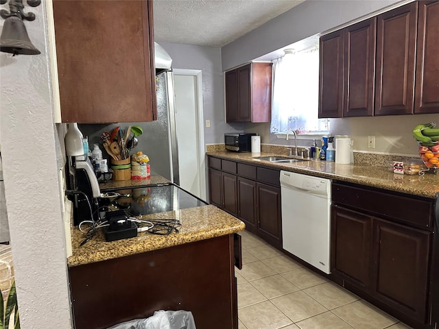 kitchen featuring light stone countertops, a textured ceiling, sink, white dishwasher, and light tile patterned floors