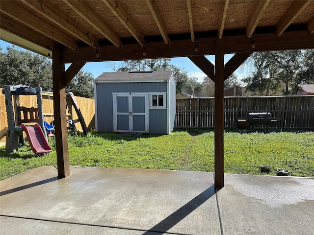 view of patio with a playground and a shed