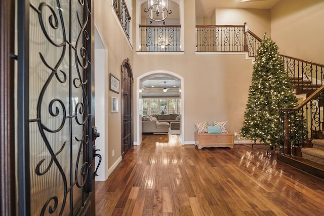 foyer with hardwood / wood-style flooring, a chandelier, and a high ceiling