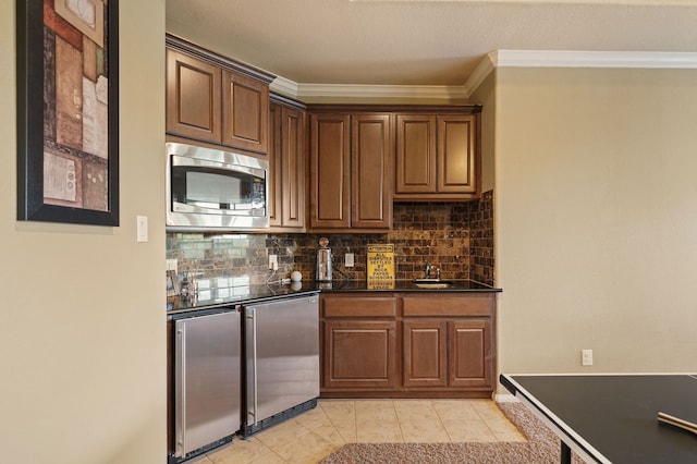 kitchen featuring stainless steel microwave, fridge, light tile patterned floors, ornamental molding, and backsplash