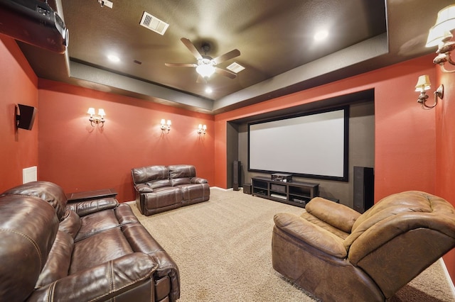 home theater with carpet flooring, ceiling fan, and a raised ceiling