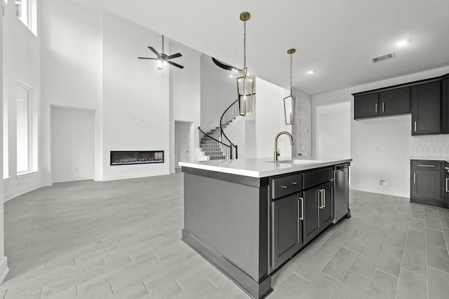 kitchen featuring sink, stainless steel dishwasher, plenty of natural light, an island with sink, and ceiling fan