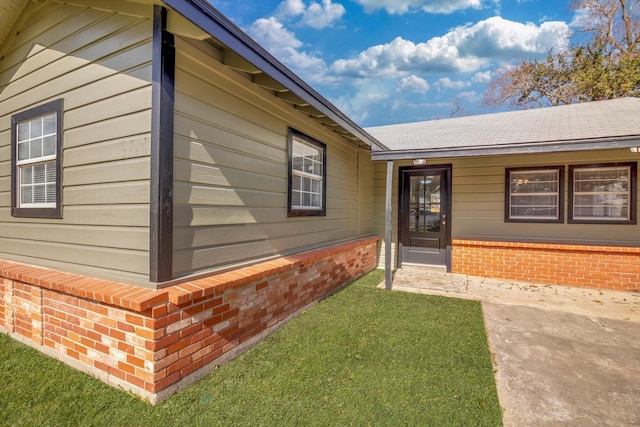 property entrance with a lawn