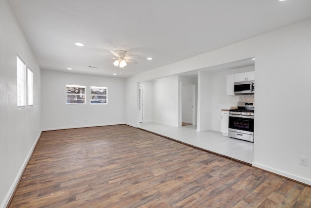 unfurnished living room featuring ceiling fan and light hardwood / wood-style flooring