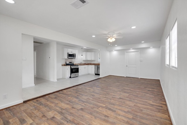 unfurnished living room with ceiling fan and light hardwood / wood-style floors