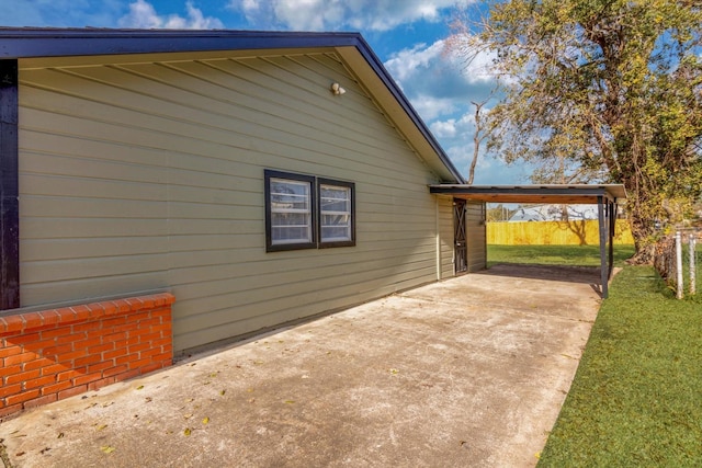 view of property exterior featuring a carport, a lawn, and a patio