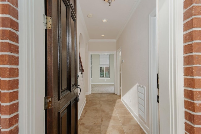 corridor with light tile patterned floors and ornamental molding