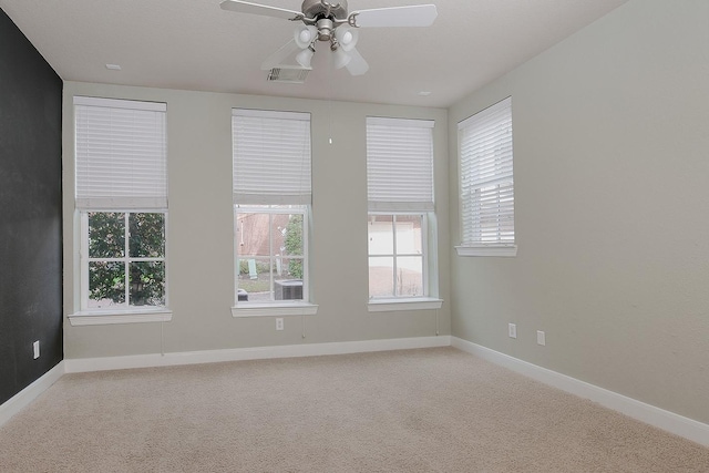 empty room with ceiling fan and light carpet