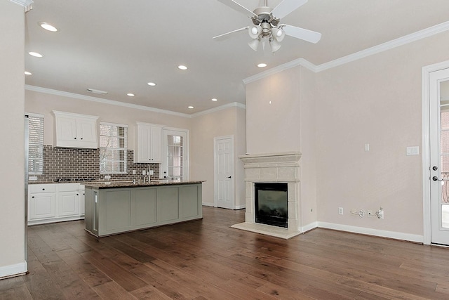 kitchen featuring white cabinetry, ceiling fan, tasteful backsplash, dark wood-type flooring, and a center island