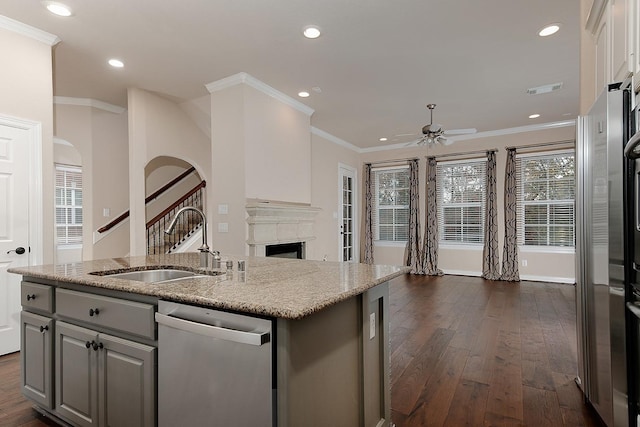 kitchen featuring ceiling fan, dishwasher, sink, an island with sink, and gray cabinetry