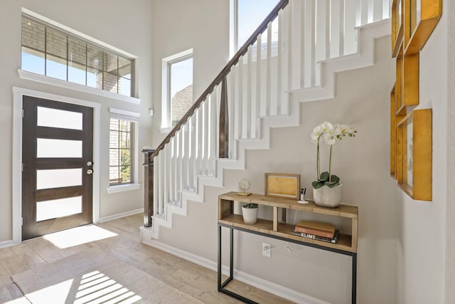 foyer featuring a towering ceiling and light hardwood / wood-style flooring