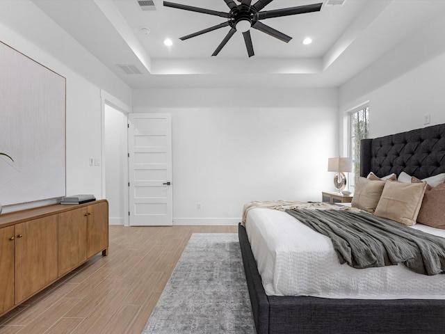 bedroom featuring a raised ceiling and ceiling fan