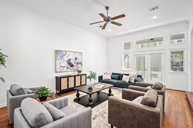 living room with ceiling fan, ornamental molding, and wood-type flooring