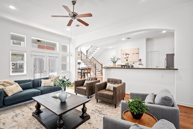 living room featuring crown molding, ceiling fan, and light wood-type flooring