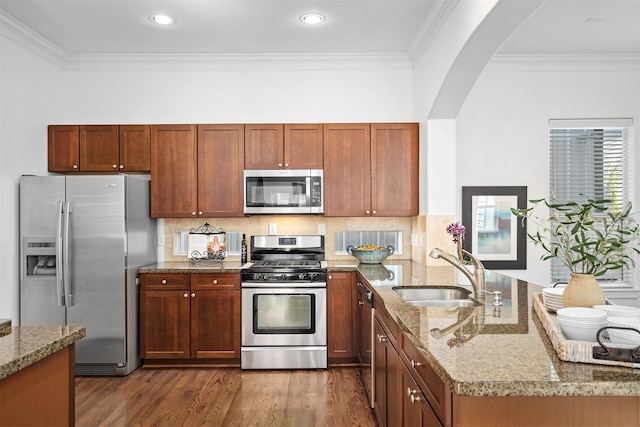 kitchen featuring appliances with stainless steel finishes, sink, light stone counters, and kitchen peninsula