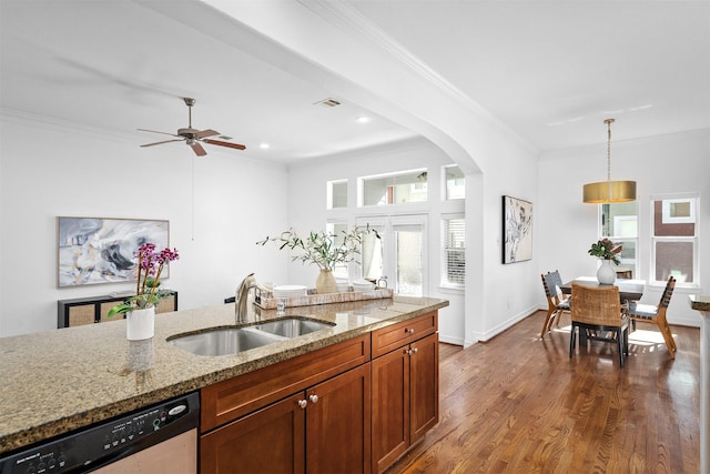 kitchen with sink, hanging light fixtures, dark hardwood / wood-style flooring, dishwasher, and light stone countertops