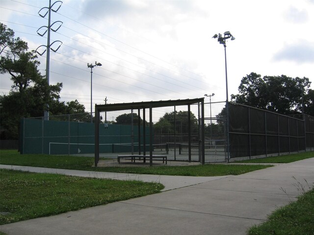 view of home's community featuring tennis court