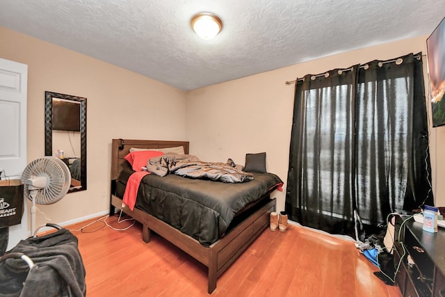 bedroom with a textured ceiling and hardwood / wood-style flooring