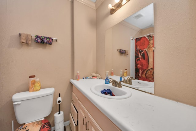 bathroom featuring toilet, vanity, and ornamental molding