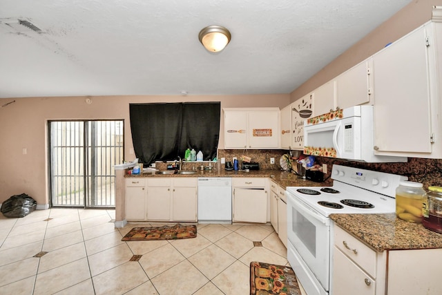 kitchen with white appliances, white cabinets, dark stone counters, decorative backsplash, and sink