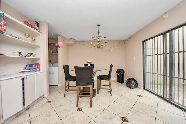 tiled dining room featuring washer and dryer and a chandelier