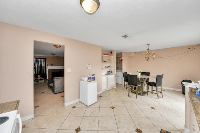 dining space featuring built in features, a notable chandelier, and light tile patterned flooring