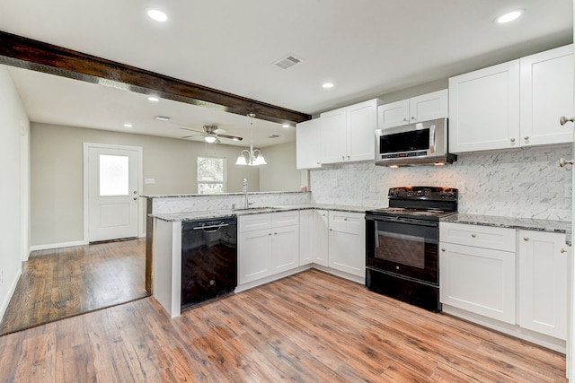 kitchen with black appliances, beamed ceiling, kitchen peninsula, and white cabinetry