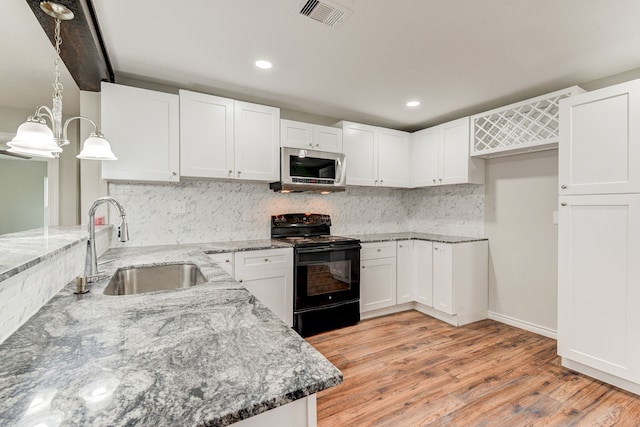 kitchen featuring white cabinets, decorative light fixtures, black / electric stove, and sink