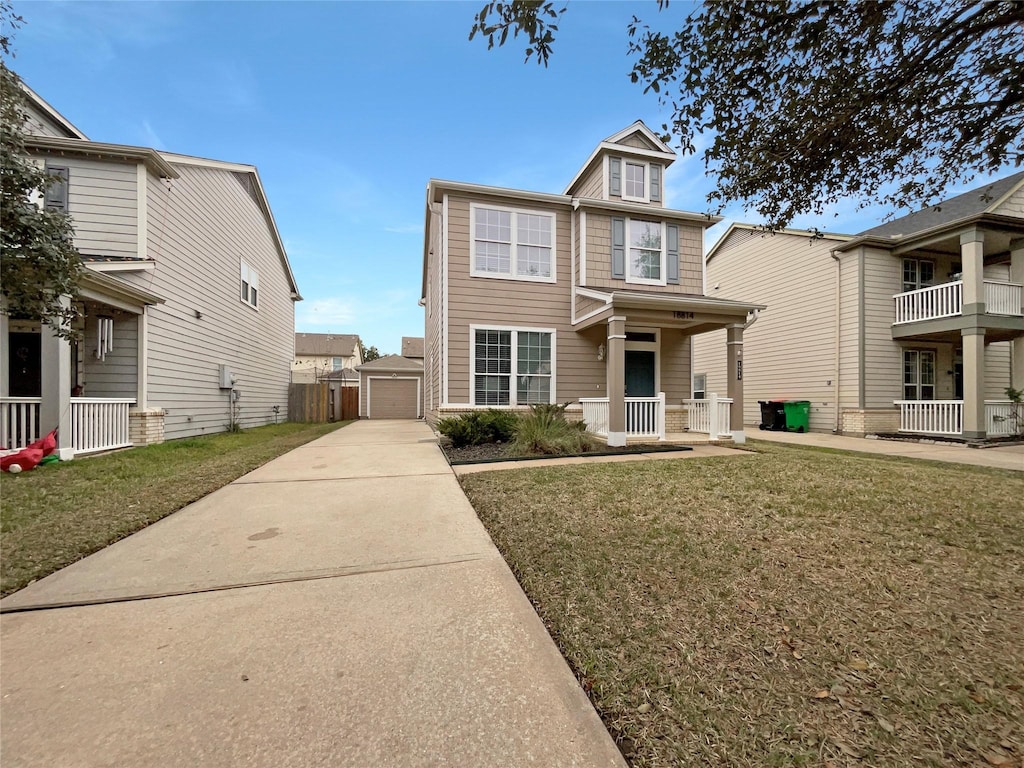 view of front facade featuring a front lawn, a garage, a porch, and an outdoor structure