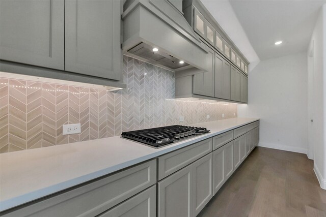 13115 Brookwood Bend Ln, Conroe, TX 77302 - kitchen featuring stainless steel gas stovetop, custom exhaust hood, light countertops, decorative backsplash, and baseboards