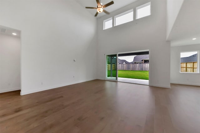 13115 Brookwood Bend Ln, Conroe, TX 77302 - unfurnished living room with ceiling fan, wood finished floors, a towering ceiling, baseboards, and recessed lighting