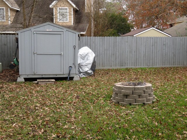 view of yard with a storage shed and a fire pit