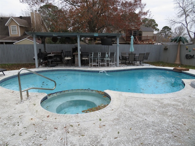 view of swimming pool featuring a patio area and an in ground hot tub