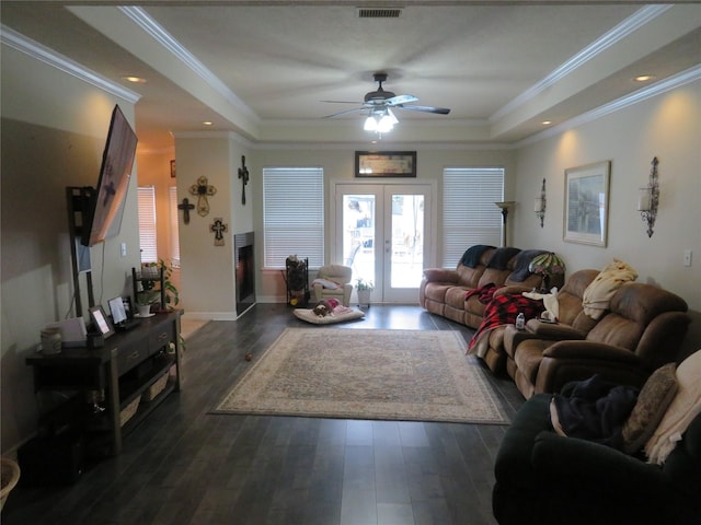 living room featuring ceiling fan, french doors, dark wood-type flooring, and a tray ceiling