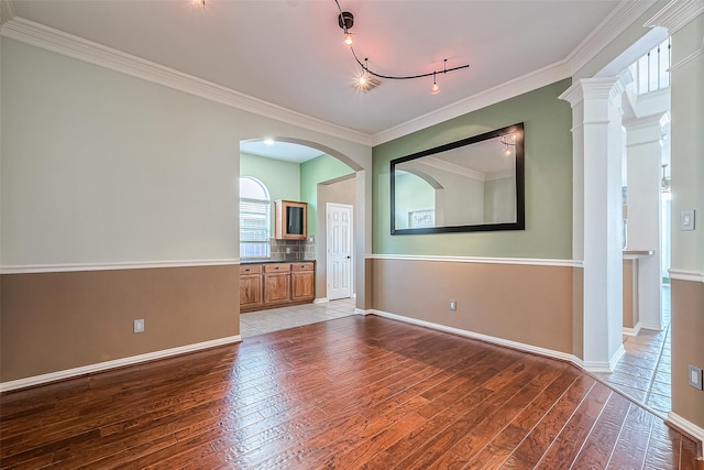 unfurnished room with ornamental molding, track lighting, and hardwood / wood-style flooring