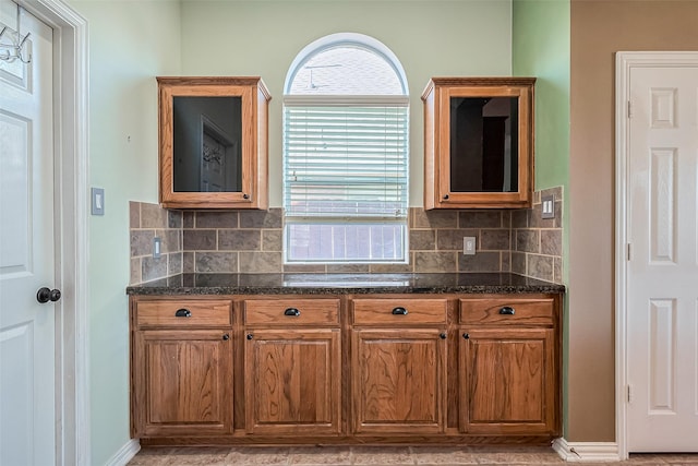 kitchen featuring backsplash and dark stone countertops