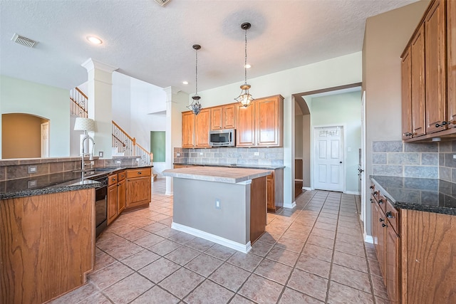 kitchen featuring backsplash, pendant lighting, kitchen peninsula, sink, and a textured ceiling