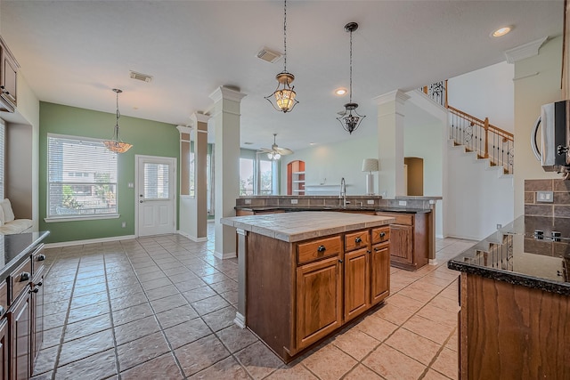 kitchen with ceiling fan, pendant lighting, a wealth of natural light, and a kitchen island