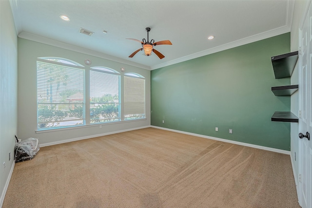 unfurnished room with ceiling fan, light colored carpet, and ornamental molding