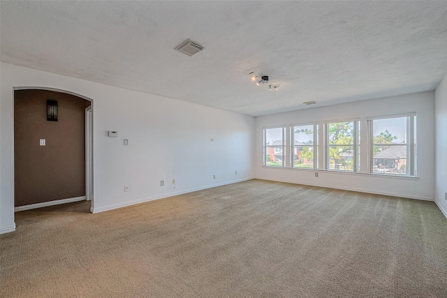 carpeted spare room featuring a textured ceiling