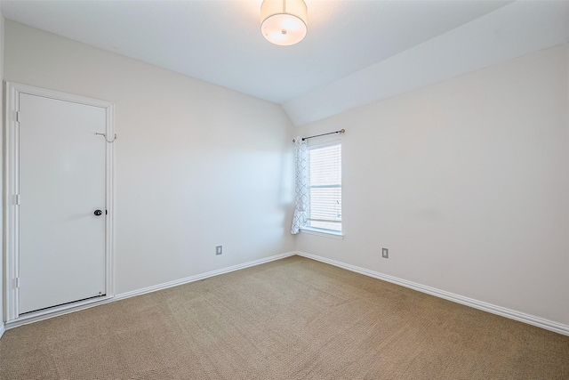 carpeted empty room with lofted ceiling